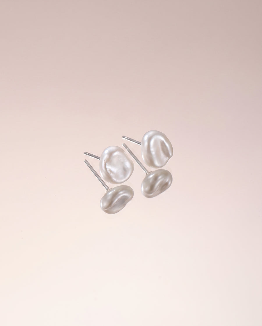 Petite Baroque Pearl Studs freshwater pearl earring on a glossy pedestal