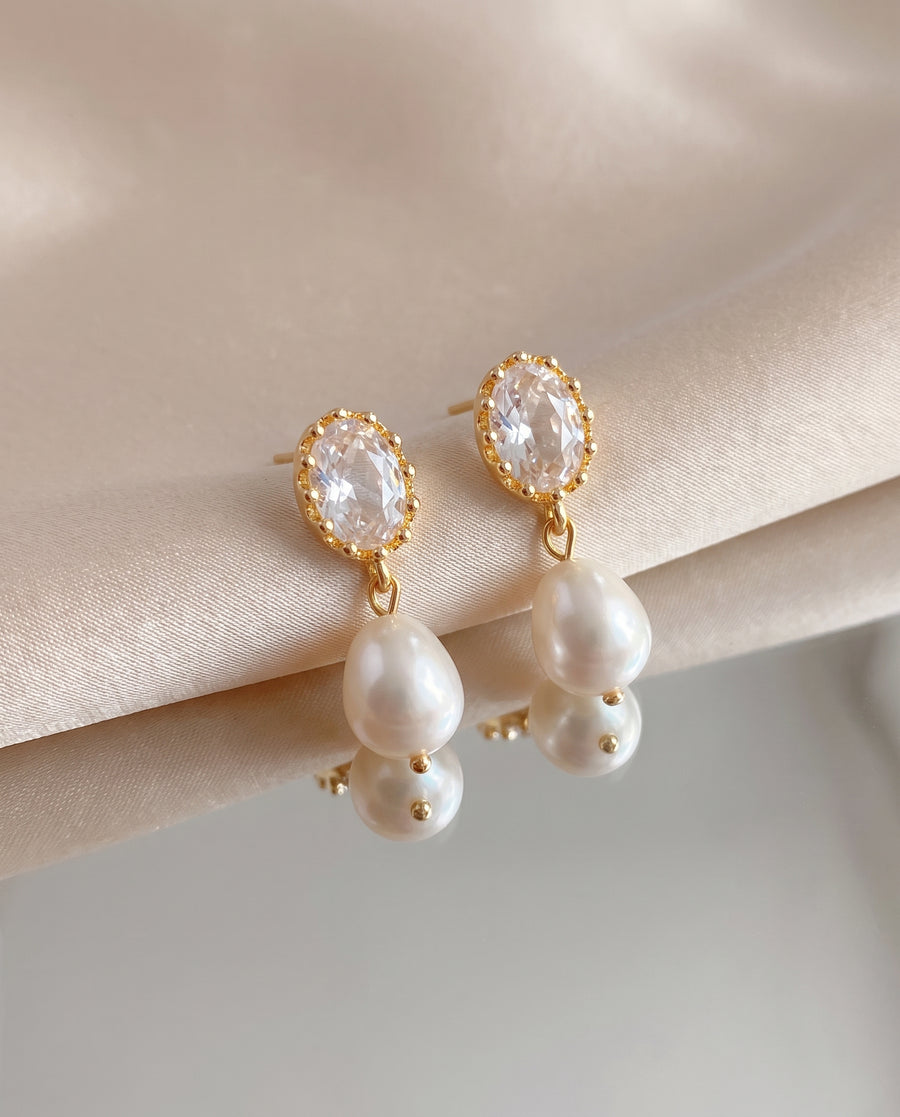 Oval Crystal Pearl Drops freshwater pearl earring on a glossy pedestal
