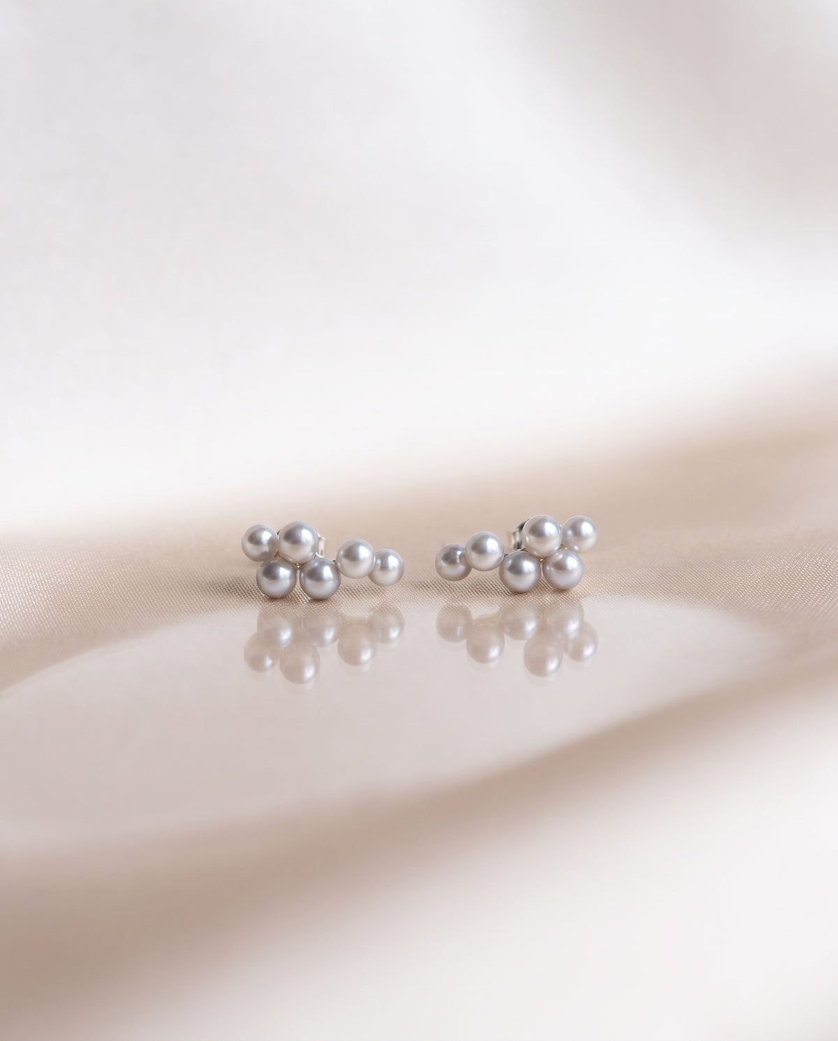 Grey Pearl Climber Studs freshwater pearl earring on a glossy pedestal