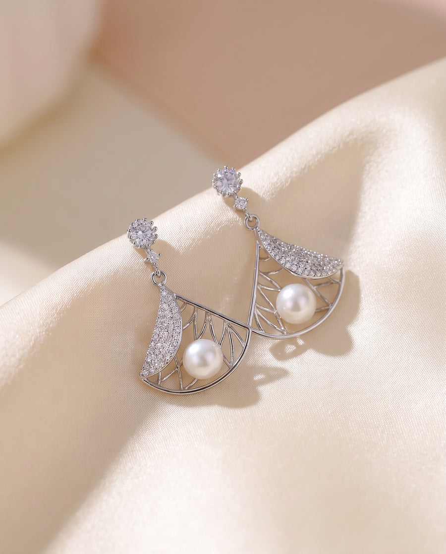 Deco Fan Pearl Drop Earrings draped on champagne silk