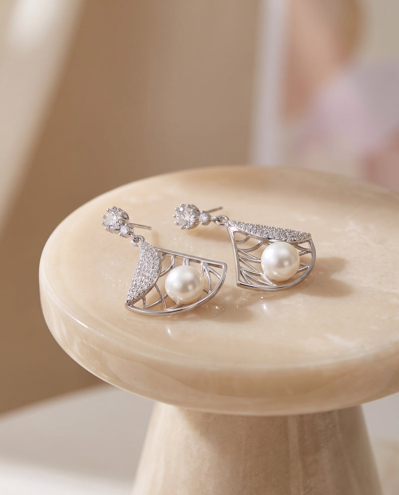 Deco Fan Pearl Drop Earrings on a glossy pedestal