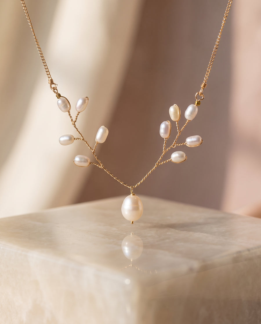 Pearl Vine Necklace on a glossy pedestal